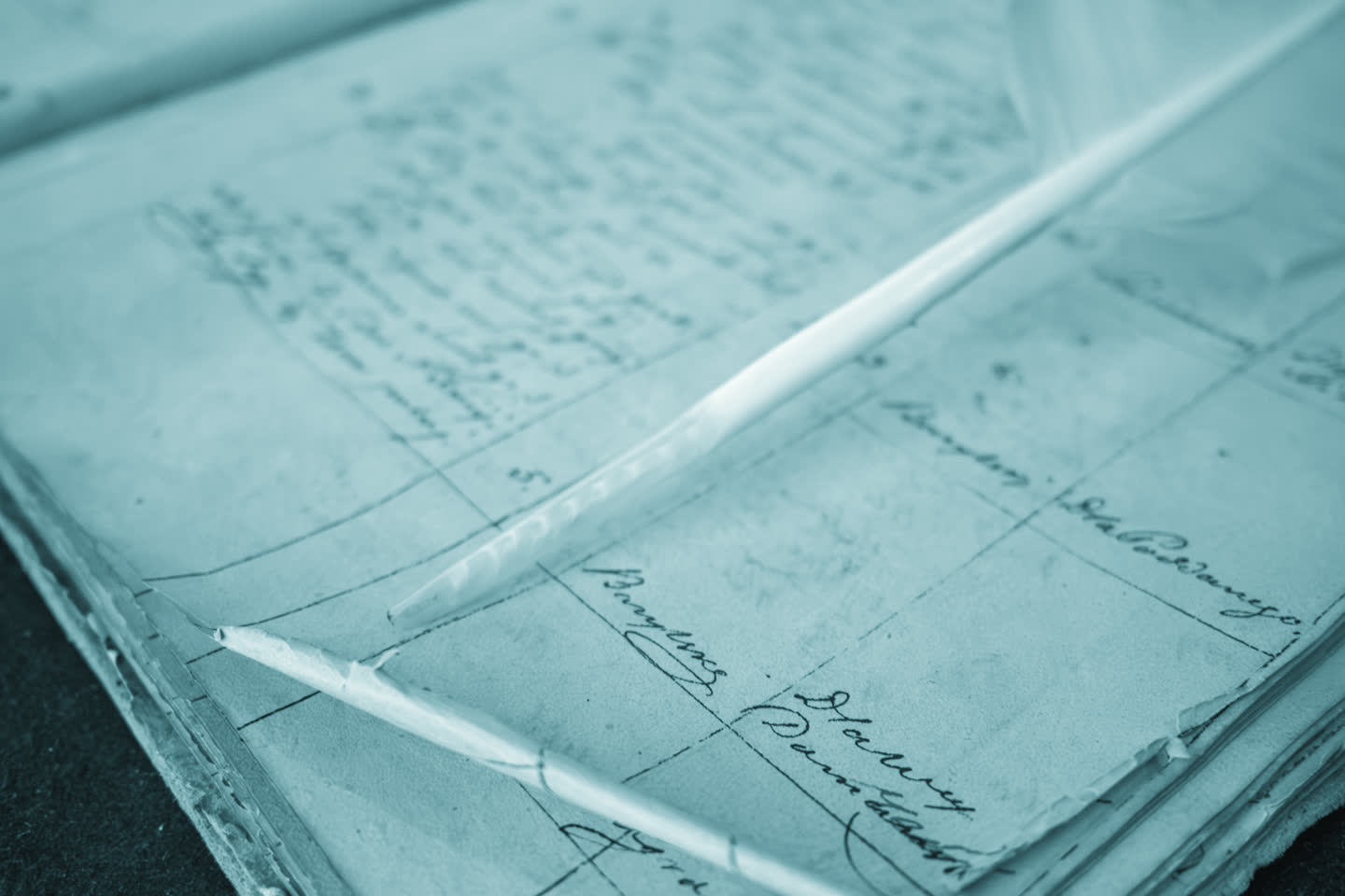 A pen resting across a written ledger page