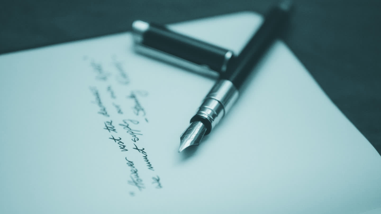 A pen resting on a page of handwriting